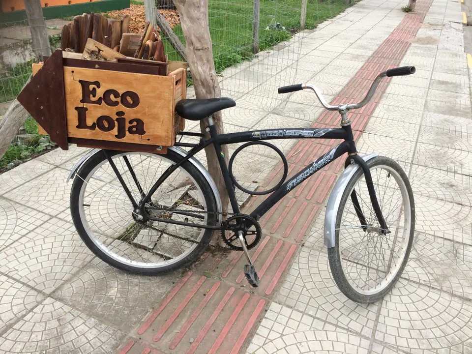 Bicicleta com caixote de madeira escrito "Eco Loja" na calçada